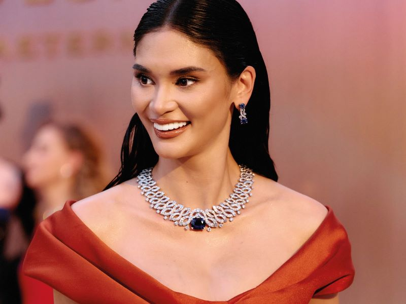 Pia Wurtzbach at the Siem Reap high-jewelry dinner, wearing a woven diamond necklace set with a large blue gemstone and a matching drop earring